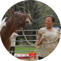 Experiential Learning with Horses - Paint-colored horse neighs as woman looks on, laughing